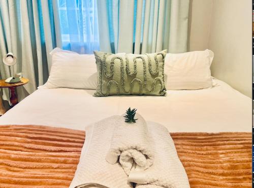 a bed with a blanket and a pillow on it at Milnerton Cottage in Cape Town