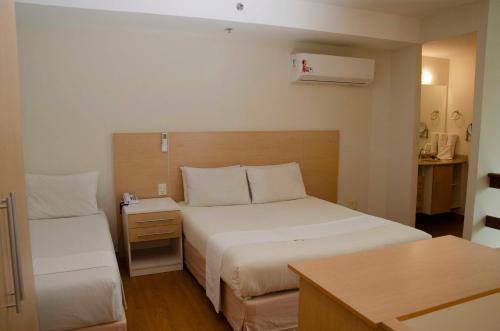 a hotel room with a bed and a desk at Hotel City Hall in São José dos Campos