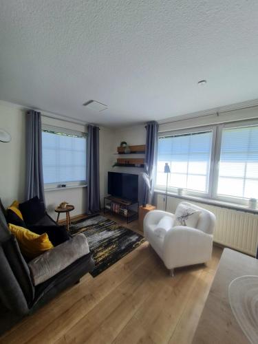 a living room with a couch and a chair at DAS kleine Haus in Wandlitz