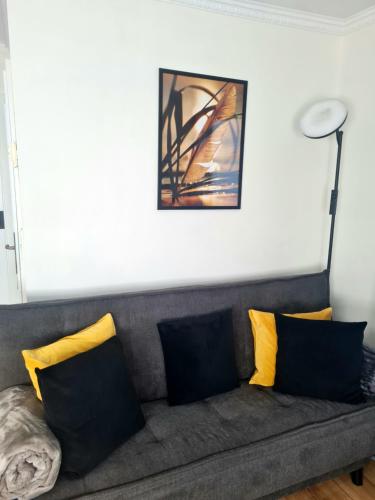 a living room with a couch with yellow pillows at DAS kleine Haus in Wandlitz