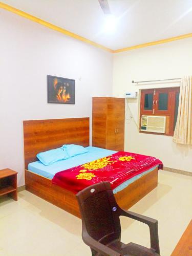 a bedroom with a bed with a red blanket on it at Shri radha rani dham in Vrindāvan