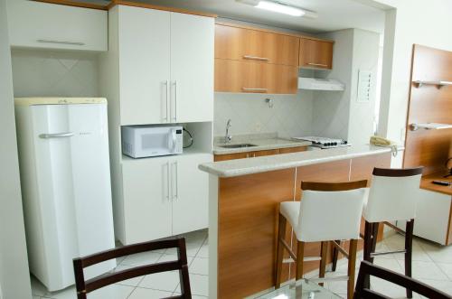 a kitchen with white cabinets and white appliances at Hotel City Hall in São José dos Campos