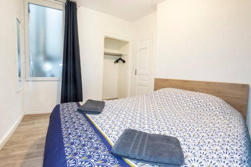 Un dormitorio con una cama con un edredón azul y blanco. en L'escale - Centre ville - 3 étoiles, en Bourg-en-Bresse