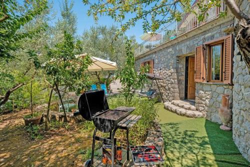 a barbecue grill in the yard of a house at Cynara holiday house in Massa Lubrense