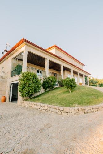 a large building with a grass yard in front of it at Encosta do Sol in Abadim