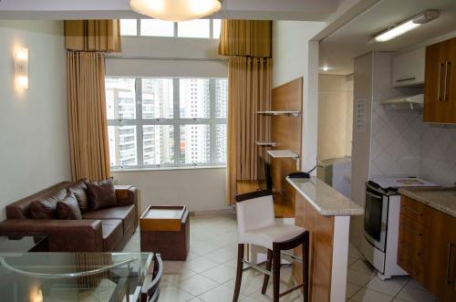 a kitchen and living room with a couch and a table at Hotel City Hall in São José dos Campos
