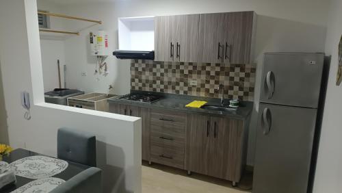 a kitchen with a stainless steel refrigerator and wooden cabinets at Circacia city in Circasia