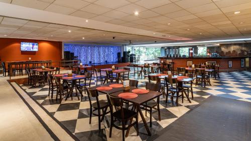 a restaurant with tables and chairs in a room at Rio Quente Resorts - Hotel Giardino in Rio Quente