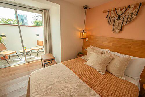 a bedroom with a bed and a large window at La Martina Boutique Hotel in Medellín