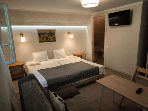 a hotel room with a bed and a table at Viesu māja Sprīdīši in Tērvete