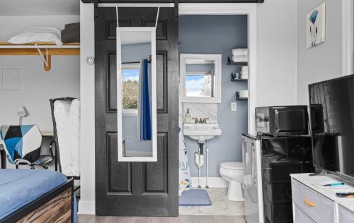 a bedroom with a bed and a bathroom with a door at Washington Park Motel Standard Suite in Norwell