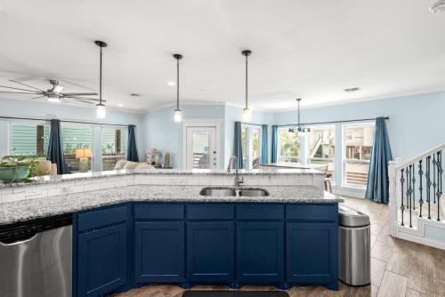 a kitchen with blue cabinets and a large sink at Sunrise Paradise - Pet Friendly! Community Pool! in Mustang Beach
