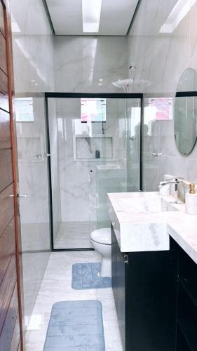a white bathroom with a shower and a toilet at AMAZON INn JACARÉ in Cruzeiro do Sul