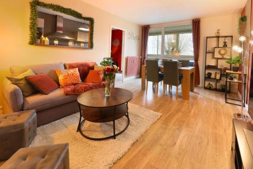 a living room with a couch and a table at Le Cocon des Pros', calme, spacieux et tout équipé in Compiègne