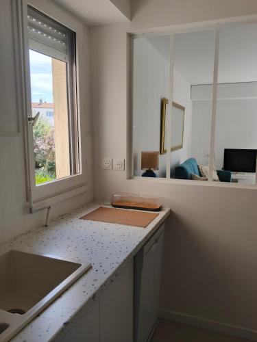 a kitchen with a counter top and a window at T2 loggia et piscine in La Rochelle