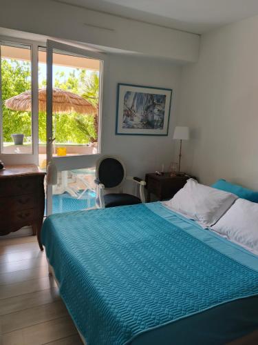 a bedroom with a bed and a desk and a window at T2 loggia et piscine in La Rochelle