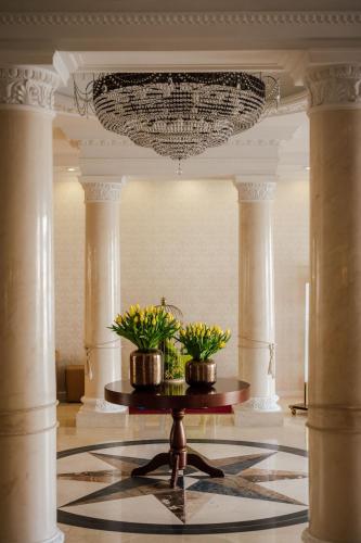 a lobby with two potted plants on a table at Hotel Splendor in Babice Nowe