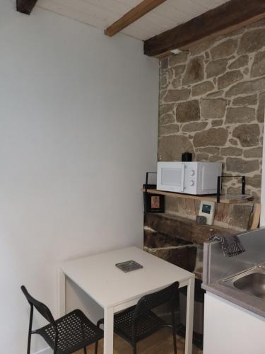 a white table and chairs in a kitchen with a stone wall at Cosy Appartement Hyper Centre-Ville in Quimper