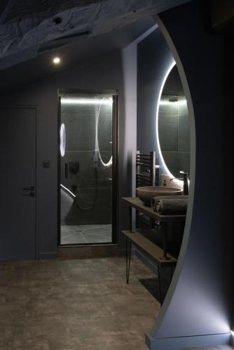 a bathroom with a large mirror and a sink at CEVA Suite Moonlight-Jacuzzi & Cinéma Centre ville in Saint-Étienne