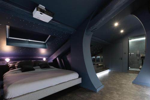 1 dormitorio con paredes de color púrpura, 1 cama y baño en CEVA Suite Moonlight-Jacuzzi & Cinéma Centre ville, en Saint-Étienne