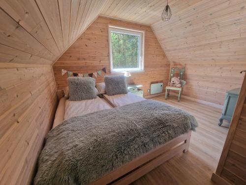 NiepoczołowiceDomek pod lasem的小木屋里有一张床的卧室