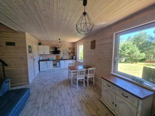NiepoczołowiceDomek pod lasem的带桌子和窗户的厨房和餐厅