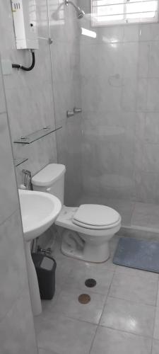 a white bathroom with a toilet and a sink at Appartamento La Marina piano terra 3 stanze in Porlamar