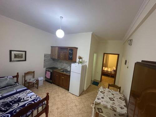 a room with a bed and a kitchen with a refrigerator at Dori 102 Apartment in Polisi i Vogël
