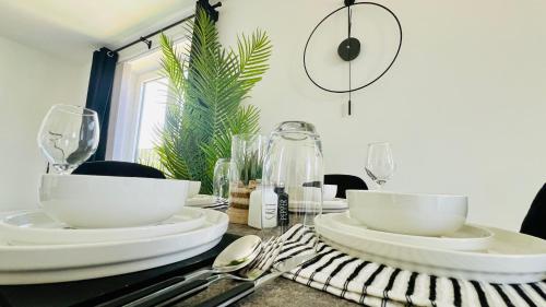 a table with white bowls and plates on it at Entire Luxury 2 Bedroom Apartment - Quiet & Central with Free Parking in Birmingham