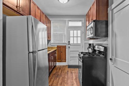 a kitchen with stainless steel appliances and wooden cabinets at Botanical Bliss | JZ Vacation Rentals in Tower Grove