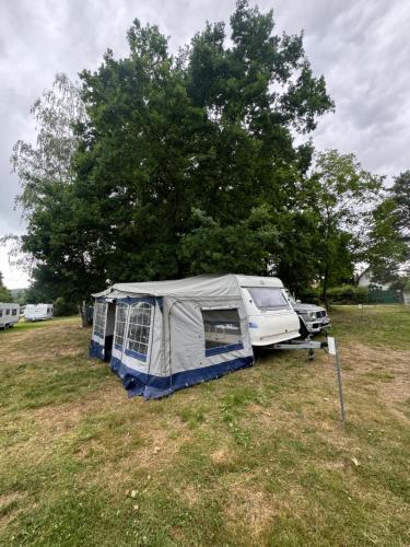 une tente et une voiture garées dans un champ dans l'établissement Karavan Ždáň, à Slapy