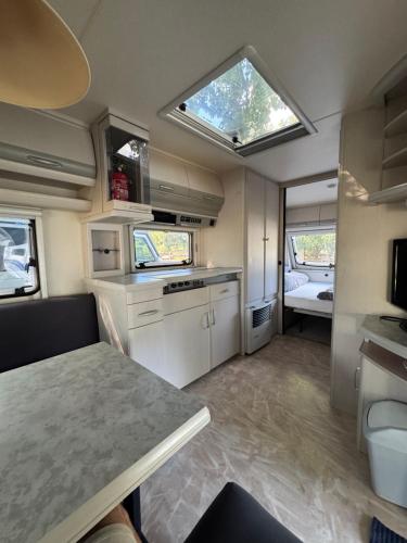 - une cuisine avec une table et une fenêtre dans l'établissement Karavan Ždáň, à Slapy