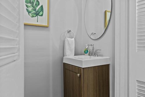 a bathroom with a sink and a mirror at Botanical Bliss | JZ Vacation Rentals in Tower Grove