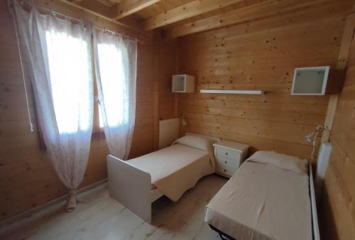 a small room with two beds and a window at Azienda agricola Panorama in Massa Marittima
