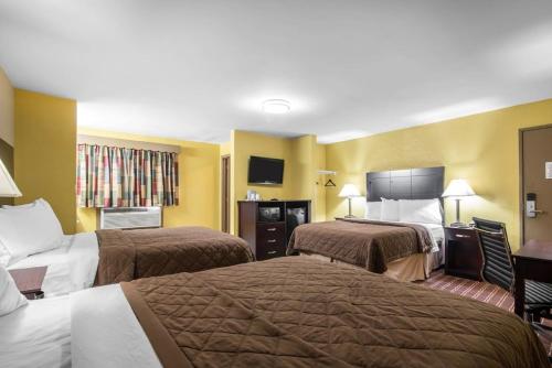 a hotel room with two beds and a television at Rodeway Inn Towanda in Towanda