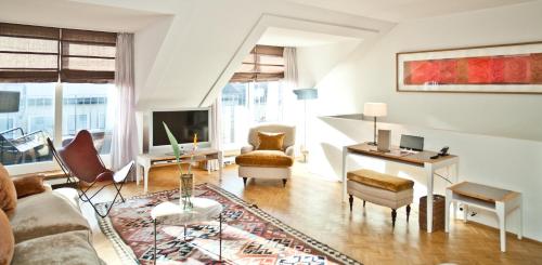a living room filled with furniture and a large window at CORTIINA Hotel in Munich