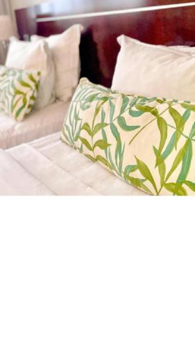 a bed with green and white sheets and pillows at Manaus Hotéis Millennium in Manaus