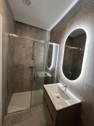 ウッチにあるApartament No 19のシャワー、洗面台、鏡を備えたバスルーム