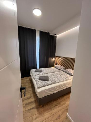 ウッチにあるApartament No 19のベッドルーム1室(ベッド1台付)、窓(黒いカーテン付)