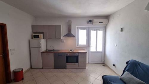 a small kitchen with a sink and a refrigerator at Apartment Ljubac 2 in Ljubač