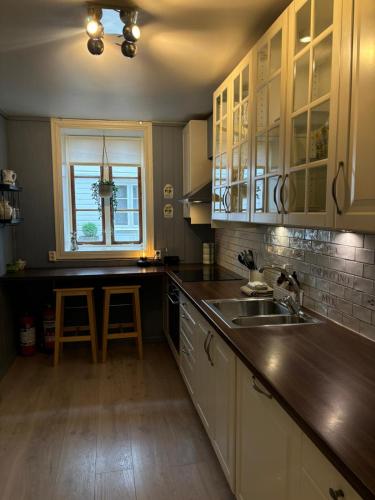 a kitchen with white cabinets and a sink and a window at Apartment in old Stavanger in Stavanger