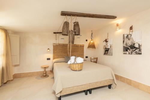 a bedroom with a bed with a basket on top of it at Bixinau Camere Museo in Tortolì