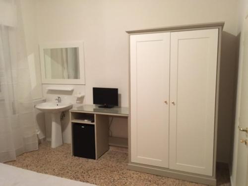 a bathroom with a sink and a desk with a computer at Ponti di Badia in Castiglione della Pescaia