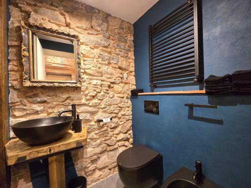 a bathroom with a sink and a stone wall at Le Diecimine - Dimora Linda in Diecimo
