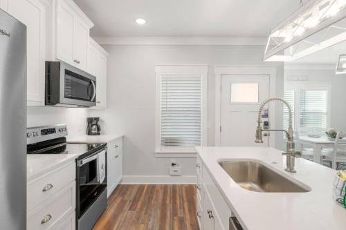a white kitchen with a sink and a microwave at Laguna Peach: 3BA 2BA retreat for 10! Explore nearby beaches & activities in Laguna Beach