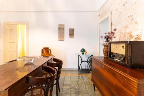 a kitchen with a table and a microwave on top of a wooden cabinet at La Casèdde in Cisternino