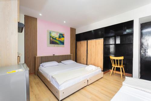 a bedroom with a bed and a chair in it at Hotel Lares 70 Laureles in Medellín