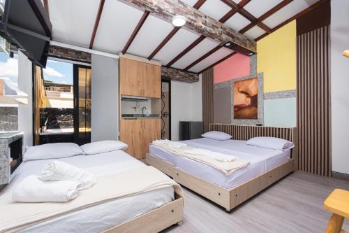 a bedroom with two beds and a table at Hotel Lares 70 Laureles in Medellín