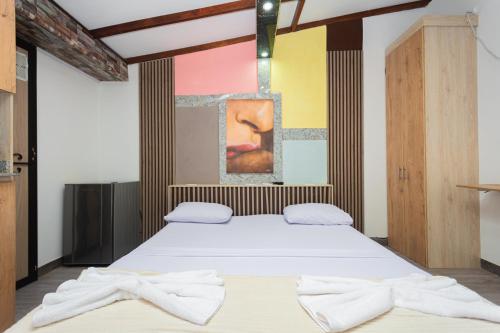 a bedroom with a bed with two towels on it at Hotel Lares 70 Laureles in Medellín