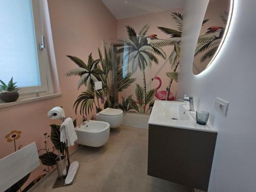 a bathroom with two sinks and palm trees on the wall at M4REE Seaside Suites & Relax in Bari
